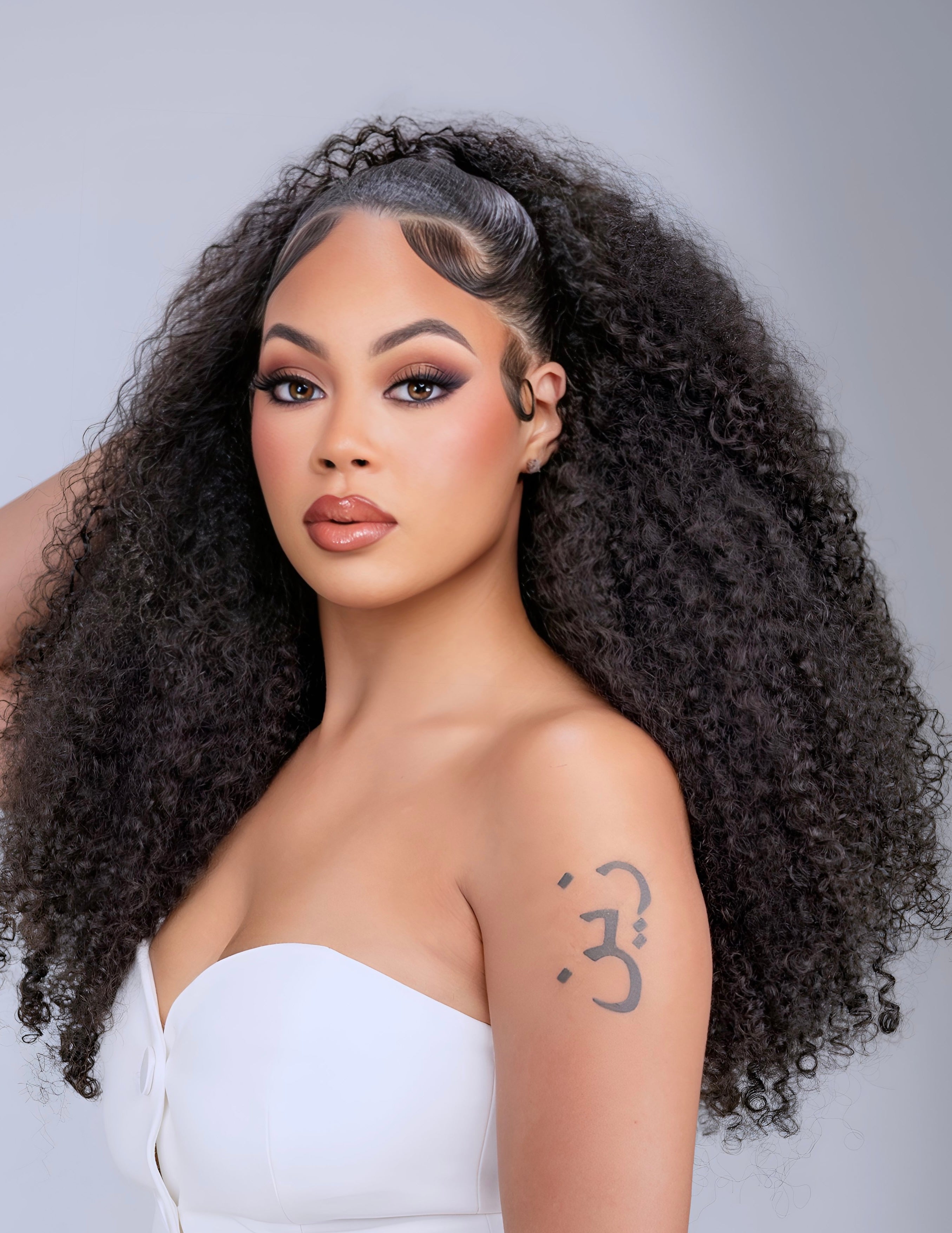 Woman wearing voluminous Burmese Curly hair extensions