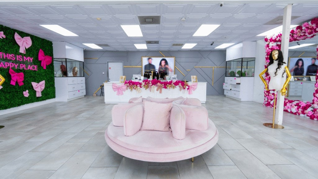 Houston South lounge with pink circular sofa, Happy Place wall, and floral mirror