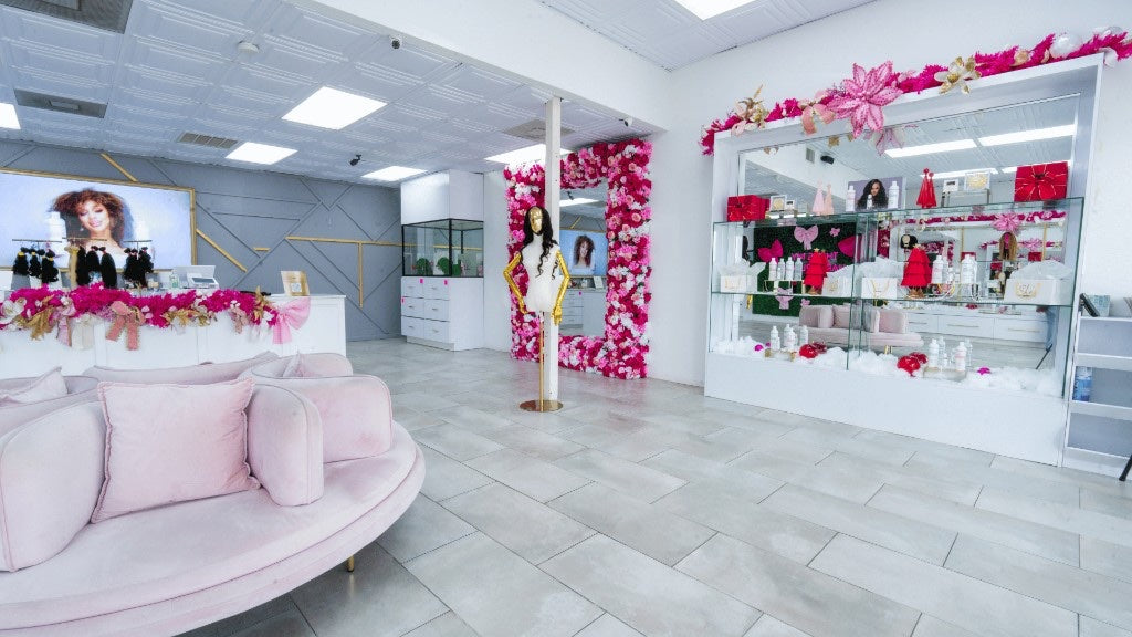 Houston South boutique floor with pink lounge seating, floral frame, and center mannequin